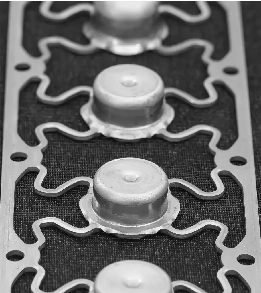 Stamped sheet metal part with punched and embossed features