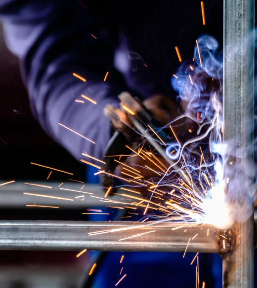 Welder creating bright sparks on a metal frame, showcasing industrial expertise.
