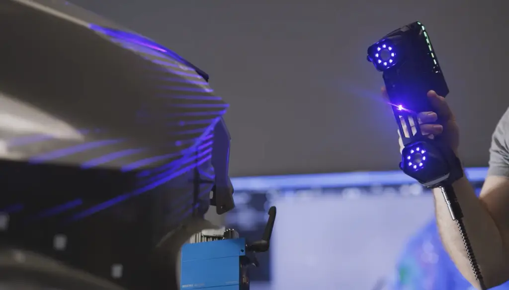 Quality technician inspecting part with 3D scanner accurate to 0.7mm